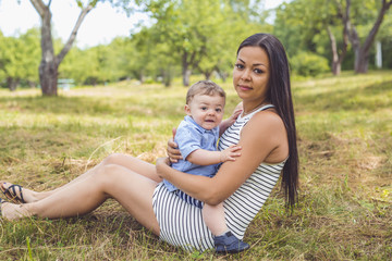 Fototapeta premium Playful woman in the garden playing with her baby son
