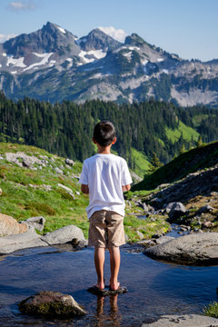 Young boy outdoor enjoying the view of the beautiful mountain sc