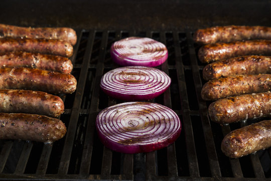 Bratwurst, Kielbasa and red onion on the grill