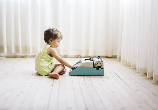 1 year old boy using a vintage typewriter