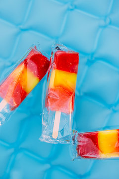 Colorful Frozen Fruit Popsicles Floating In Blue Backyard Pool
