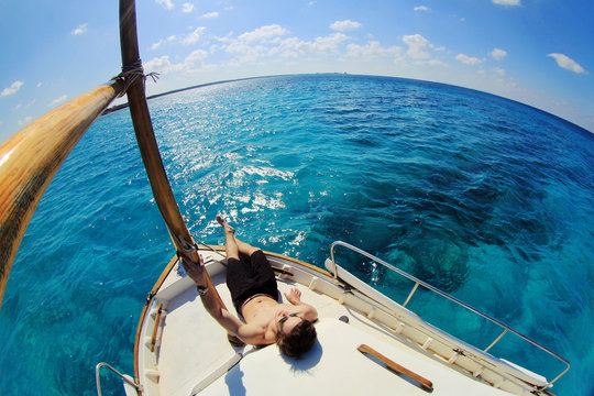 Young man relaxing on a boat in the sea