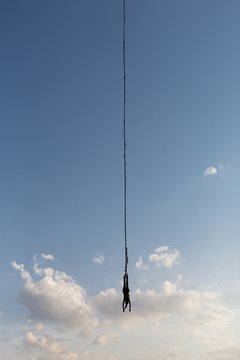 Woman hangs upside down from a bungee cord
