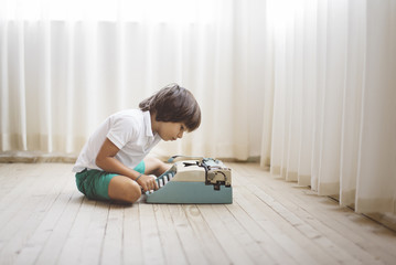 5 year old boy using a vintage typewriter