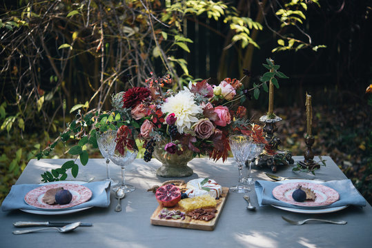 Autumn table set up in nature; Autumn flowers table for two