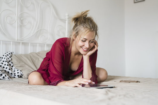 Young woman using a tablet on the bed