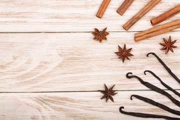 vanilla sticks, cinnamon, coffee beans and star anise on white wooden background with copy space for your text. Top view