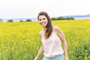 Happy young woman over yellow meadow