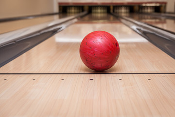 red bowling ball on the track in the bowling center