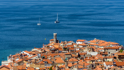 Fototapeta premium Aerial view of Piran, town on the Adriatic Sea, one of Slovenia's major tourist attractions, with medieval architecture, narrow streets and compact houses.