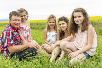 Fototapeta premium Family outdoors on a yellow field