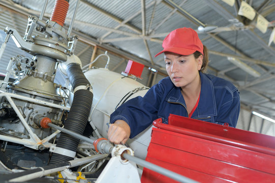 female mechanic working on helicopter engine