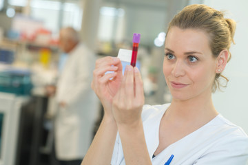 nurse is holding a tube with blood probe