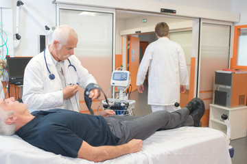 Obraz premium doctor is measuring blood pressure using hand device