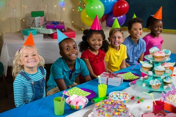 Portrait of children sitting at table
