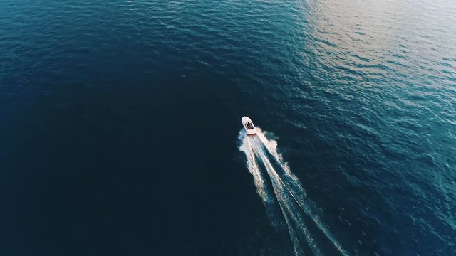 Bird eye view of luxurious speed boat sailing on the turquoise lake. It perfectly describes traveling to new amazing destinations and summer vacation on the lake