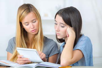 Two female teenagers reading notes