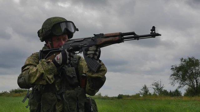 A russian soldier with a machine gun on a military firing range shooting at a target HD