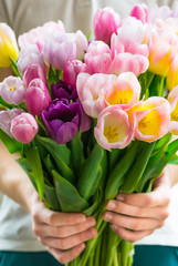 The Boy presents Bunch of Colorful Tulips to his mother