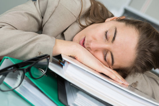 female employee sleeping on her desk at the office