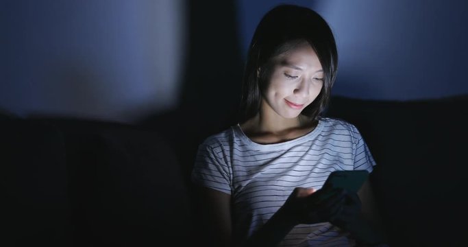 Woman looking at mobile phone at night