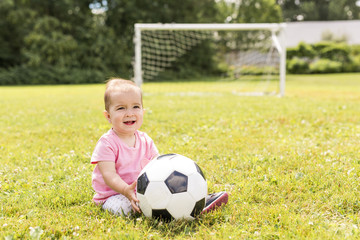 cute baby girl playing on grass with ball