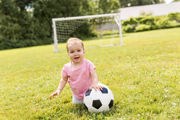 cute baby girl playing on grass with ball