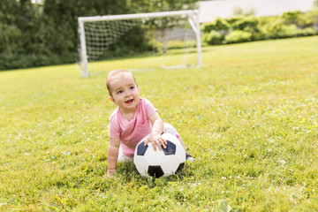 Naklejka premium cute baby girl playing on grass with ball