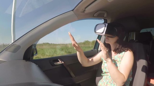 Girl a car rides around the city in the helmet of virtual reality. 360 VR Technology.