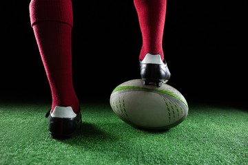 Close up of sportsperson stepping on rugby ball