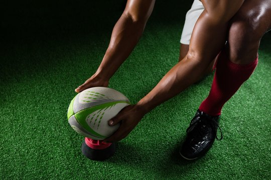 High Angle View Of Sportsman Keeping Rugby Ball On Tee