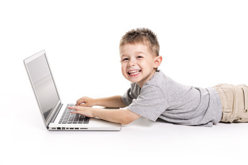 little kid with laptop lay on the ground