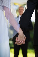 Mid section of couple holding hands