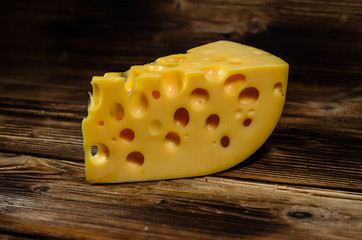 Piece of cheese on wooden table