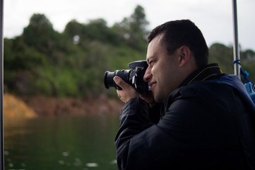 Hombre latino tomando fotos con c&aacute;mara profesional