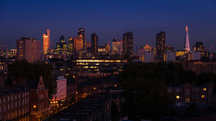 Night shot featuring the famous London skyline, including landmark buildings of the City of London, the financial powerhouse, contrasting with more traditional Victorian houses