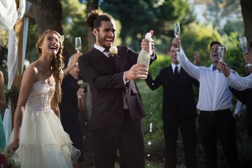  Groom opening champagne bottle at park