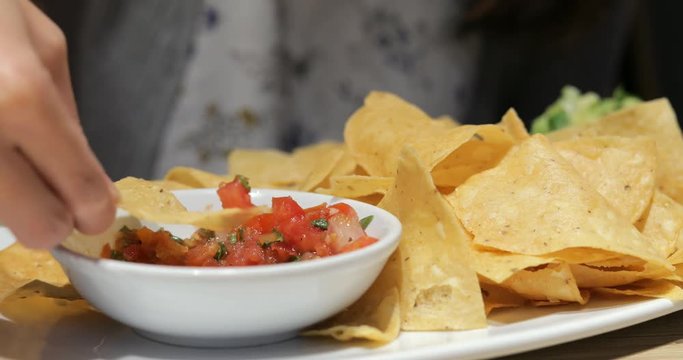 Woman enjoy dipping sauce with Mexican Crisp in restaurant