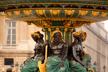 Telephoto detail of three statues on a fountain located in Place de La Concorde, Paris, France