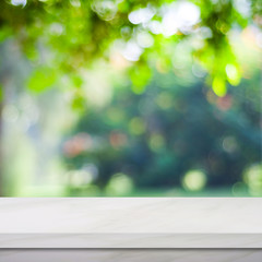 Empty white marble table over blur green park background