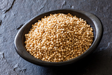 Puffed quinoa seeds (Chenopodium quinoa) in a traditional black clay dish