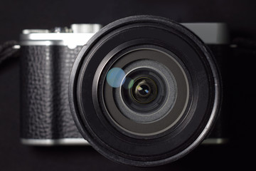 Camera body and lens on black background.