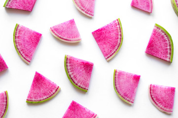 Isolated watermelon radish slices. Colorful pink pieces on white background.