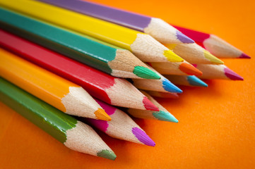 Back to school and classroom supplies with  closeup on mix colored pencils on orange background