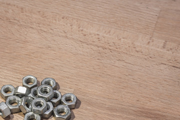 metal nuts on a wood background