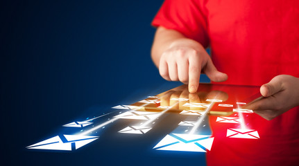 Hand holding tablet and sending email icons