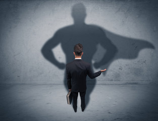 Successful businessman with superhero shadow