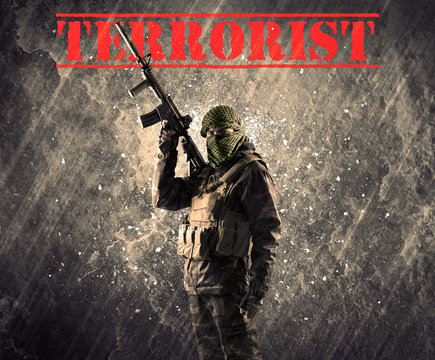 Portrait of man holding rifle with terrorist sign against grungy background