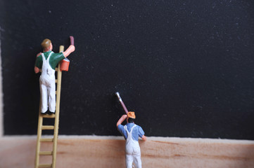 Miniature figure working in industrial - Close up of construction and painting worker concept with selective focus.