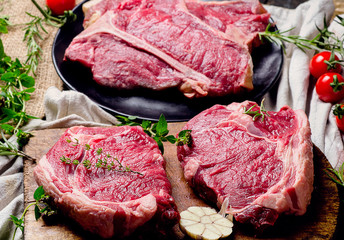 Raw beef meat on a dark wooden board.
